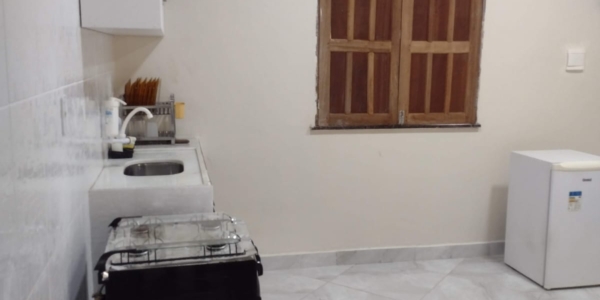 Interior da suíte com ar condicionado em casa de temporada; imóvel conta com cozinha equipada e varanda aconchegante